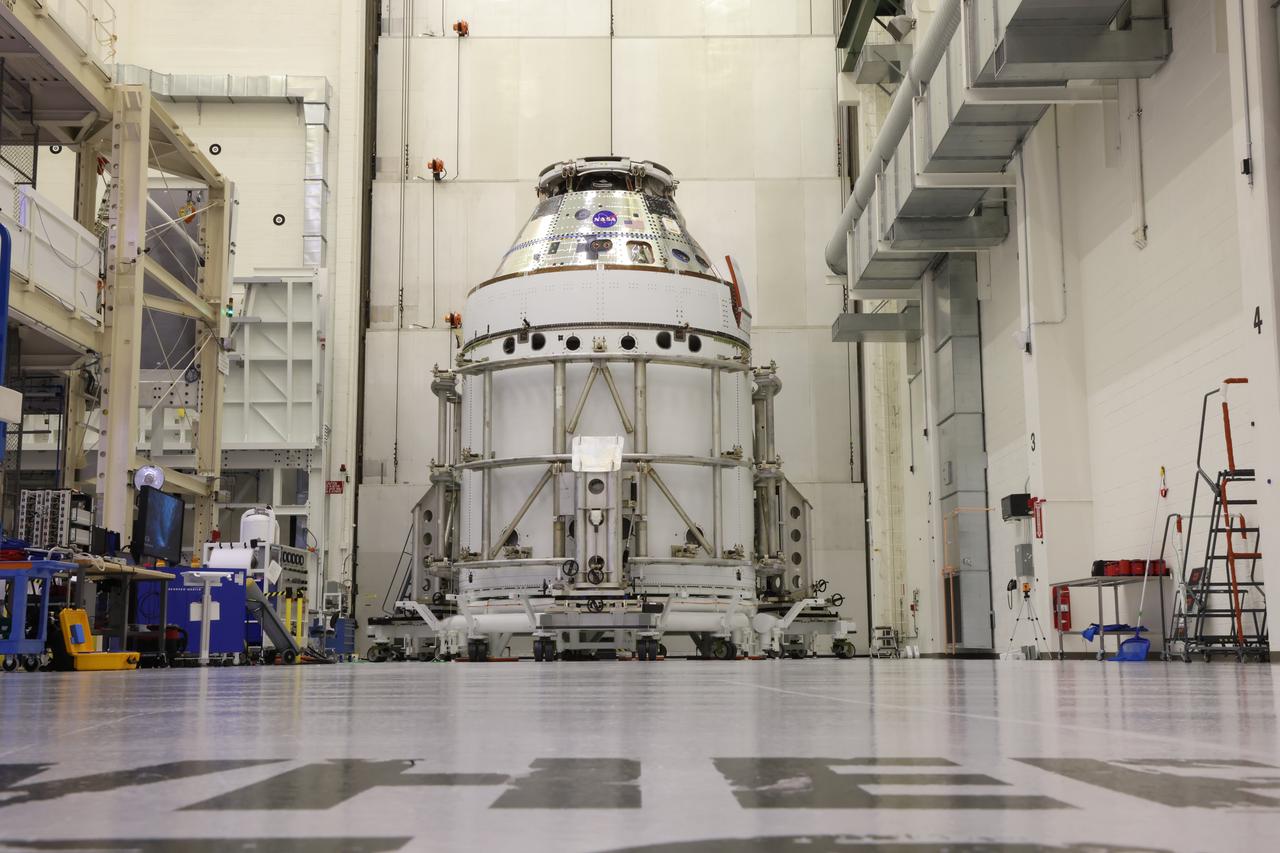 The Artemis II Orion spacecraft sits in the transfer aisle in the Neil A. Armstrong Operations and Checkout Building at NASA’s Kennedy Space Center in Florida following successful installation of three spacecraft adapter jettison fairings on Wednesday, March 19, 2025. The fairings encapsulate the service module and protect the solar array wings, shielding them from the heat, wind, and acoustics of launch and ascent, as well as help redistribute the load between Orion and the massive thrust of the SLS (Space Launch System) rocket during liftoff and ascent. Once the spacecraft is above the atmosphere, the three fairing panels will separate from the service module reducing the mass of the spacecraft.